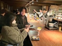 バーテンダーが目の前で作ったモクテルの写真を撮る来場者