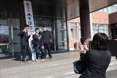 生徒玄関前で記念写真を撮る卒業生（上士幌、長尾悦郎通信員撮影）