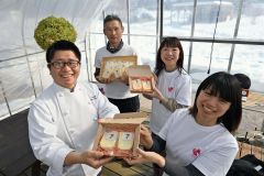 出来上がったチーズを杉山社長（左）に贈る尾崎さん（同２人目）らとかち熱中小学校の生徒
