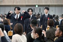 入場時、保護者席へ向かってポーズを取る卒業生（帯広大谷、須貝拓也撮影）