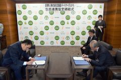 包括連携協定書に署名する小野町長（右）と川合社長（左）