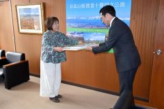 野口局長から副賞の大型絵本を受け取る中村代表