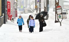降雪の中、登校する児童（６日午前７時４５分ごろ、大樹町内で。金野和彦撮影）