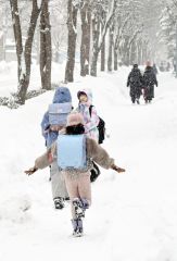 雪が降る中、走って登校する児童ら（６日午前８時５分ごろ、幕別札内南小付近で、村瀬恵理子撮影）