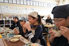 揚げパンをおいしそうに食べる下音小の６年生ら