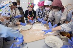 高田会長（左から５人目）とつきたての餅を丸める児童ら