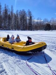 スノーモービルが引っ張るゴムボートで雪の上を疾走した子どもたち