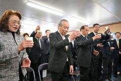 牛乳で乾杯する小野氏（前列左から２人目）と光子夫人（同左）ら