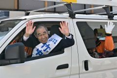 選挙カーから手を振る竹中氏（１１日午前９時２５分ごろ、Ａコープ上士幌店ルピナ前で。須貝拓也撮影）