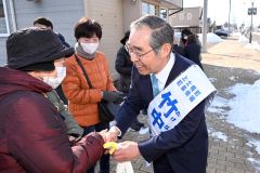 有権者と握手を交わす竹中氏（１１日午前９時２０分ごろ、Ａコープ上士幌店ルピナ前で。須貝拓也撮影）