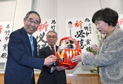 ７選を決めダルマにＶサインを入れる竹中氏（左、１１日午後５時１５分ごろ、塩原真撮影）