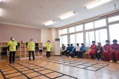 松岡代表（左から２人目）の説明に合わせて実演する隊員