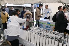 牛乳などが入ったプレゼントを受け取る来場客ら（１４日午前１０時半ごろ）