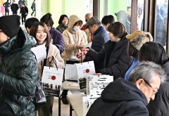 プレゼントを受け取り笑顔の来場者(16日正午ごろ、塩原真撮影)