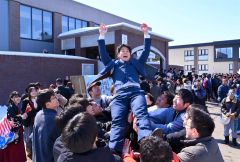 仲間から胴上げをされる卒業生（１９日、午前１１時４５分ごろ。金野和彦撮影）