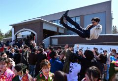 仲間から胴上げをされる卒業生（１９日午前１１時４０分ごろ。金野和彦撮影）