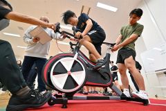 ワットバイクを全力でこぐ高校生。６秒間と３０秒間の記録で走行能力を測った