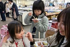 ２種類のサツマイモを食べ比べする親子連れ（２２日午前１０時２０分ごろ、須貝拓也撮影）