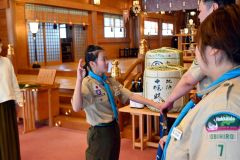 手を掲げ、ボーイ隊の約束を守ると誓う遠藤さん（左）