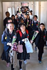 一輪の花を手に思い出いっぱいの校舎を後にする卒業生（帯広、塩原真撮影）