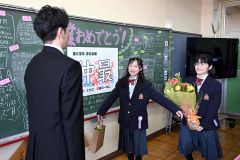 お世話になった担任の樋口寛人教諭に花束を手渡す卒業生（帯広花園、須貝拓也撮影）
