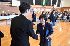 担任の樋口寛人教諭と握手して退場する卒業生（帯広花園、須貝拓也撮影）