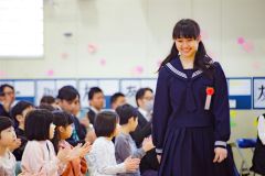 門出の喜びや、照れくささから、はにかんだ笑顔を見せながら入場する卒業生（広尾、石原秀樹通信員撮影）