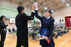 担任の平野龍二教諭とハイタッチを交わし、式場を後にする卒業生（池田、澤村真理子撮影）