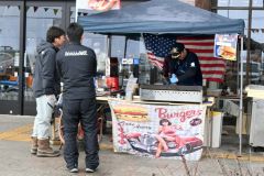 屋外で調理・販売されたハンバーガー。注文客は完成を心待ちにしていた