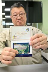 十勝ダム運用開始４０周年を記念したダムカードを紹介する三上支所長。カード下の指で隠された部分に記念シールが貼られている