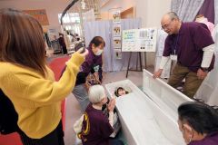 入棺体験する来場者（２９日午前１１時半ごろ、助川かおる通信員撮影）