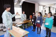 かんなの使い方を教える帯広工業高校生（左）と説明を聞く参加者（右）。（助川かおる通信員撮影）