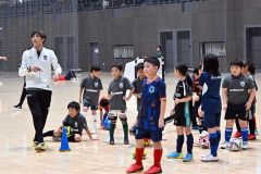 子どもたちに優しくサッカーを指導する松島仁さん(左)