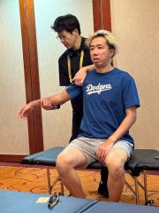 昨年１０月に香港で開かれた「ベースボール５」のワールドカップで選手に施術を行う後藤さん（左、本人提供