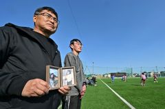 笑理菜さんの遺影を持ち試合観戦する昭朋さん（左）と笑理菜さんの叔父の杉原勝人さん