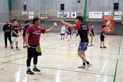 交流会でダブルスを組み、好プレーにハイタッチするオビネシアのメンバーと帯広大谷高校の部員