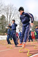 ミニハードルを跳ぶ中学生