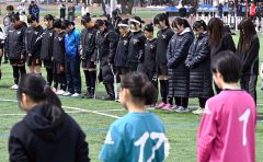 西村さんをしのび黙とうをささげる帯北ロッカフォルテ十勝合同チーム（正面）ら参加選手たち（６日正午ごろ、帯広北高校グラウンドで。塩原真撮影）