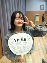観客のメッセージが書き込まれた応援うちわを掲げる高校生