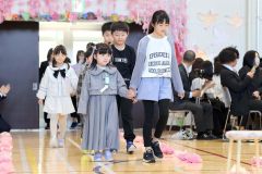 ６年生と手をつないで入場―少し緊張の新入生（芽室西、長尾悦郎通信員撮影）
