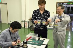 ＨＯＳＰＯ人工衛星用ロケットの射場「ＬＣ－１」の缶バッジを制作する会員ら