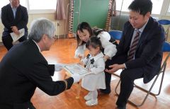 北原分団長（左）から認定書を受け取る杏光ちゃん