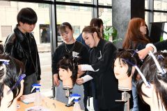 講師のカットの手本を真剣な様子でみつめる学生
