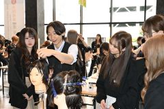 講師のカットの手本を真剣な様子でみつめる学生