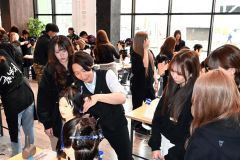 講師のカットの手本を真剣な様子でみつめる学生