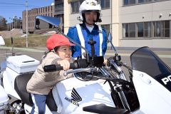 白バイにまたがりハンドルに手を伸ばす児童（須貝拓也撮影）