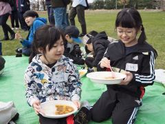 清掃後、ボランティアが振る舞ったカレーを食べる子どもたち