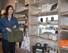 なつぞら市場の一角に開設したリネン製品店頭販売コーナーを紹介する帝繊の中西さん