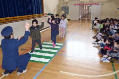 上に大きく手を挙げるなど、ハンドサインを実践する児童ら