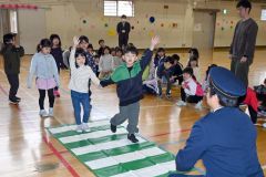 上に大きく手を挙げるなど、ハンドサインを実践する児童ら